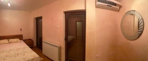 Schlafzimmer mit einem Bett und einem Wandspiegel in der Unterkunft Giardino in Petrovac na Moru