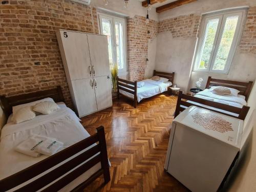 a room with two beds in a brick wall at Step to Kotor bay Guesthouse in Kotor