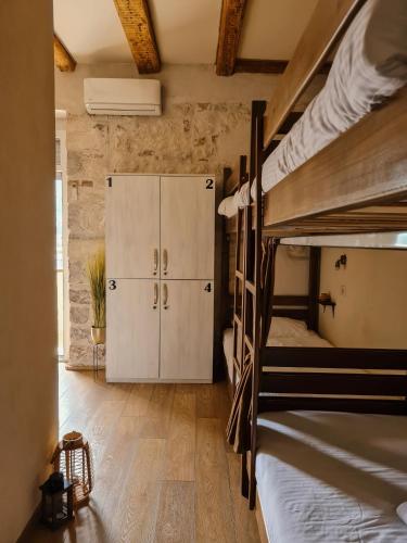 a room with two bunk beds and a cabinet at Step to Kotor bay Guesthouse in Kotor