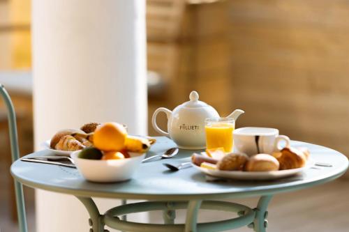 a table with a tray of breakfast foods and orange juice at L'Oasis Hotel in Fréjus