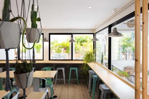 a restaurant with green chairs and tables and windows at L'Oasis Hotel in Fréjus