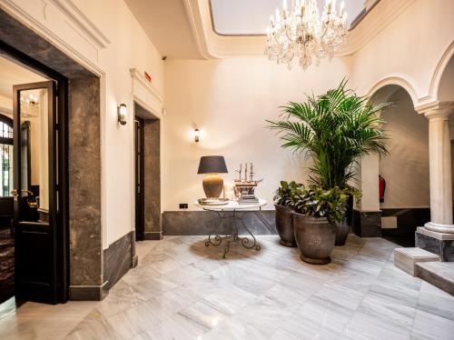a hallway with a table and potted plants at Boutique Hotel Casa Cánovas in Cádiz