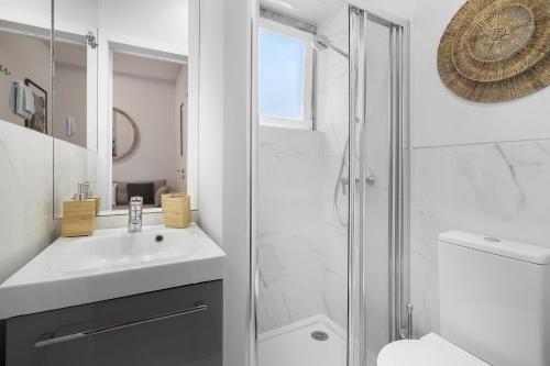 a white bathroom with a sink and a shower at Cozy Apt in Lisbon with Terrace by Soulplaces in Lisbon