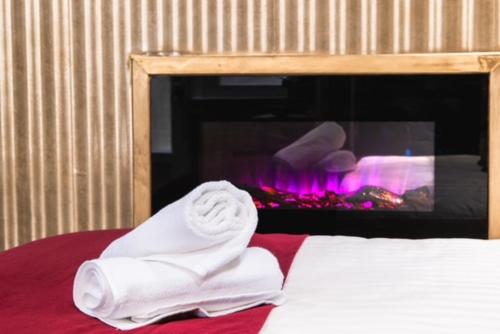 a bed with a stack of towels in front of a fireplace at Luxury Room in Dijon