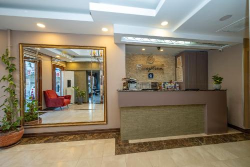 a lobby with a reception counter and a mirror at Raymond Hotel in Istanbul