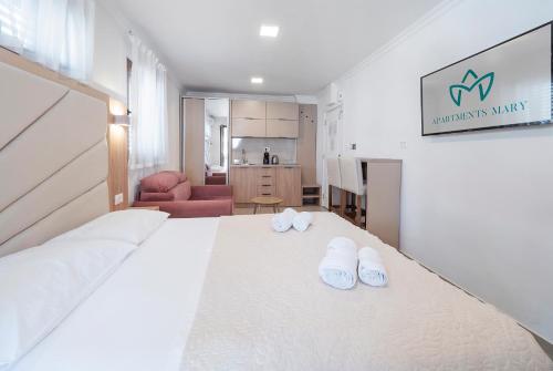 a bedroom with a bed with white slippers on it at Apartments Mary in Budva