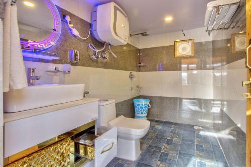 a bathroom with a toilet and a sink and a mirror at Regal Retreat in Jari