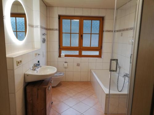 ein Badezimmer mit einem Waschbecken, einer Badewanne und einem WC in der Unterkunft Hinterbauernhof Fewo Kuhgeflüster in Stegen