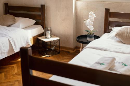 a hotel room with two beds and a table at Step to Kotor bay Guesthouse in Kotor