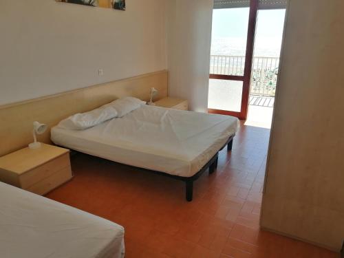 リド・ディ・イエゾロにあるResidence Il Panfilo sul Mareのベッドルーム1室(ベッド2台付)、バルコニーが備わります。