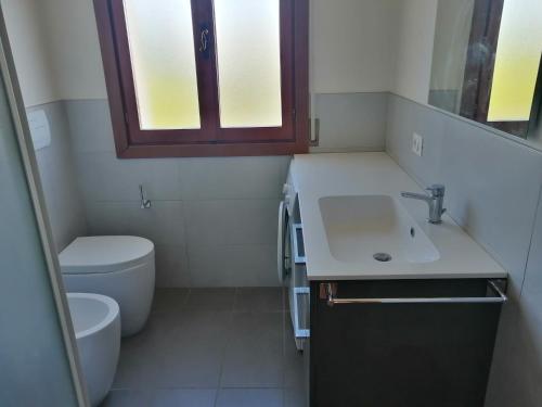 ein kleines Bad mit einem Waschbecken und einem WC in der Unterkunft Residence Il Panfilo sul Mare in Lido di Jesolo