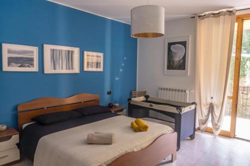 a bedroom with two beds and a blue wall at The River Nest in Lasnigo
