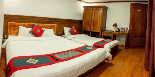 een slaapkamer met 2 bedden met rode en groene lakens bij HƯƠNG GIANG HOTEL in Sa Pa