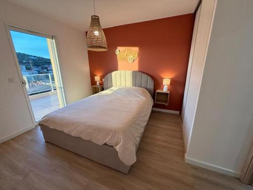 une chambre avec un lit et une grande fenêtre dans l'établissement Superbe appartement neuf 4pers, à LʼÎle-Rousse