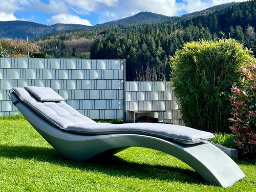 a couch sitting in the grass in a yard at WEITBLICK "entspannen - wohlfühlen - aktiv erholen" in Elzach