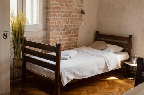 a bed in a room with a brick wall at Step to Kotor bay Guesthouse in Kotor