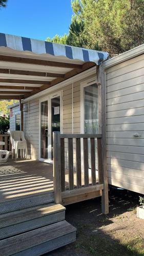 une terrasse couverte d'une maison avec une terrasse en bois dans l'établissement Mobil Home Les Charmettes 6 Personnes, aux Mathes