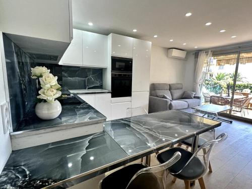 - une cuisine avec un comptoir orné d'un vase de fleurs dans l'établissement Superbe 2 Pièces Rénové Grande Terrasse et Vue Mer, à Cagnes-sur-Mer