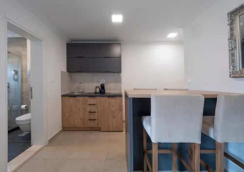 a kitchen with a bar with two white chairs at Apartments Mary in Budva