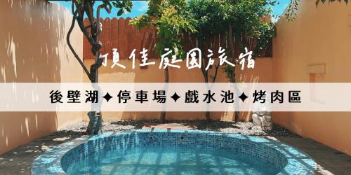 a swimming pool in a yard with a tree at Ding Jia Garden Resort in Hengchun South Gate