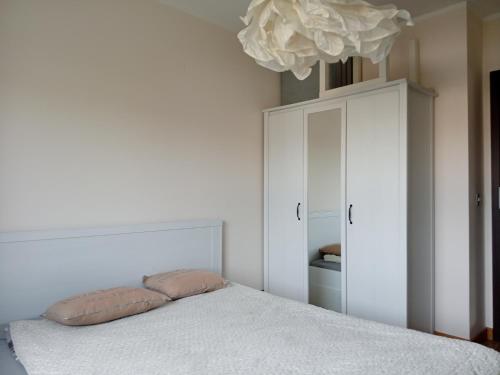 a bedroom with a bed and a white cabinet at Mieszkanie w Szczecinie in Szczecin
