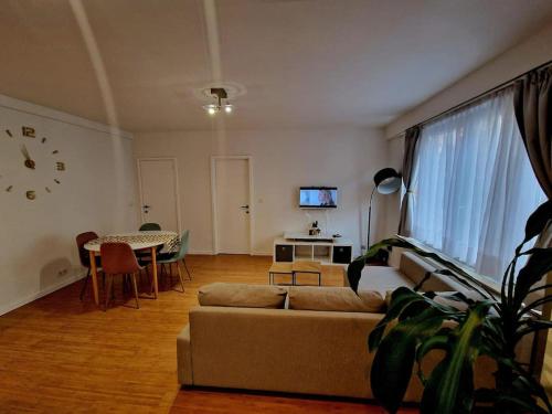 ein Wohnzimmer mit einem Sofa und einem Tisch in der Unterkunft Le cocon du midi - Appartement Cosy in Brüssel