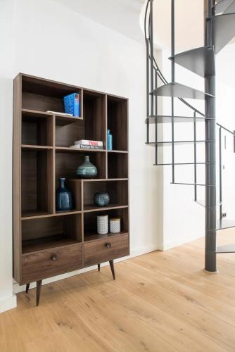 a wooden book shelf in a room with a staircase at The Guest Apartments in Den Bosch