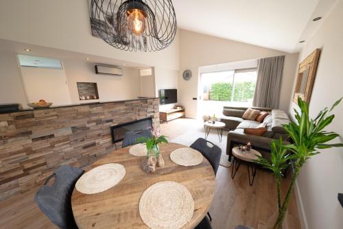 a living room with a wooden table and a fireplace at Recreatiepark de Koornmolen in Zevenhuizen