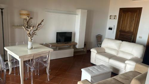 sala de estar con sofá y mesa en Prezioso appartamento con vista mozzafiato - Casa Enrica, en Castelsardo