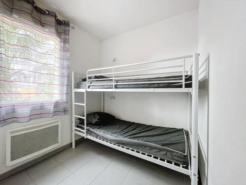 Cette chambre comprend 2 lits superposés et une fenêtre. dans l'établissement 3301-Appartement 6 couchages avec piscine, à Argelès-sur-Mer