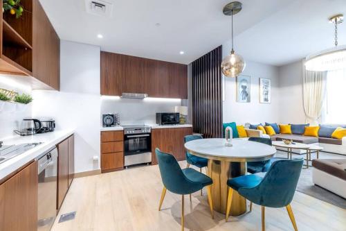 a kitchen and living room with a table and chairs at Goldbest La Mer - Luxury 1 bdr Apartment with Beachfront Pool in Dubai