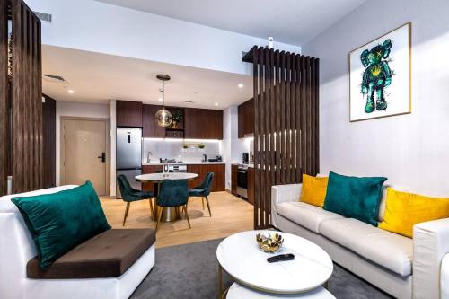 a living room with a couch and a table at Goldbest La Mer - Luxury 1 bdr Apartment with Beachfront Pool in Dubai