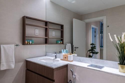 a bathroom with a sink and a mirror at Goldbest La Mer - Luxury 1 bdr Apartment with Beachfront Pool in Dubai