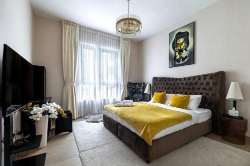 a bedroom with a large bed and a television at Goldbest La Mer - Luxury 1 bdr Apartment with Beachfront Pool in Dubai
