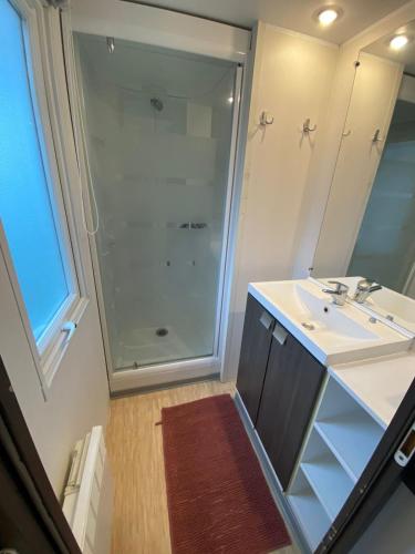 une salle de bain avec une douche en verre et un lavabo dans l'établissement hébergement sur camping 5 étoiles proche mer proche centre Houlgate, à Houlgate