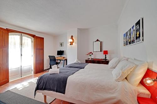 una camera con un grande letto e una scrivania di Casal Dos Machados a Boliqueime