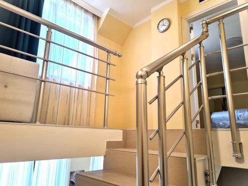 a staircase in a room with a clock on the wall at Apart-Hotel Panorama Sea LUX in Primorsko