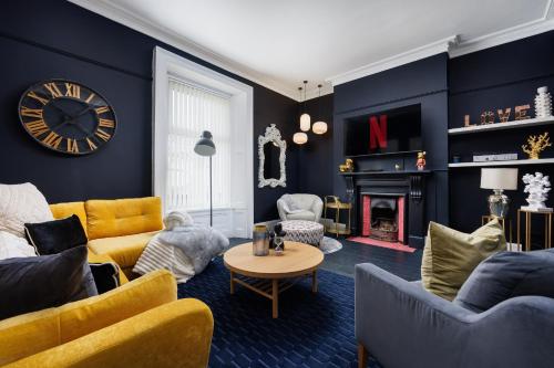 a living room with a clock on the wall at The Executive - Central Plymouth House - Sleeps 9 - Habita Property in Plymouth