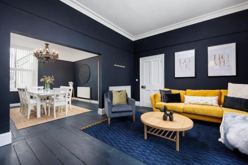 a living room with a yellow couch and a dining room at The Executive - Central Plymouth House - Sleeps 9 - Habita Property in Plymouth