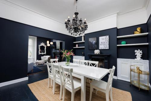 a dining room with blue walls and a white table and chairs at The Executive - Central Plymouth House - Sleeps 9 - Habita Property in Plymouth