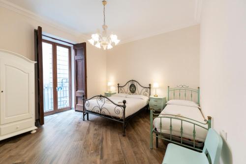 una camera con due letti e un lampadario a braccio di Plebiscito Deluxe rooms a Napoli