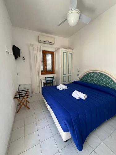 a bedroom with a blue bed with a blue blanket at La Giara in Vulcano