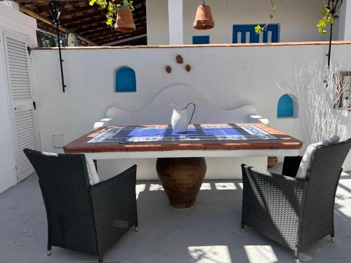a table with chairs and a vase on top of it at La Giara in Vulcano