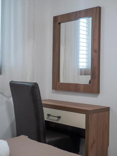 a mirror on a wall next to a desk with a chair at Apartments Mary in Budva