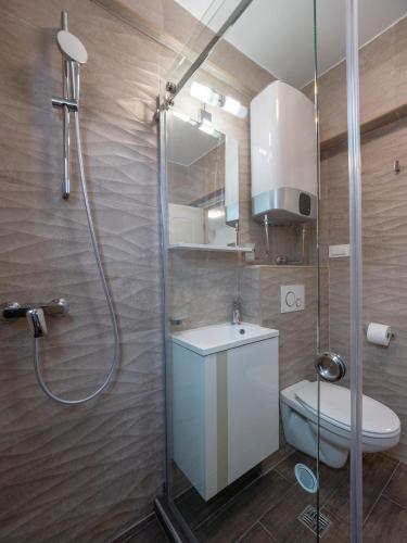 a bathroom with a shower with a toilet and a sink at Apartments Mary in Budva