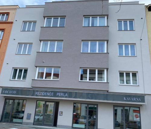 a tall white building with a store front at Perla Hradce 202 in Hradec Králové