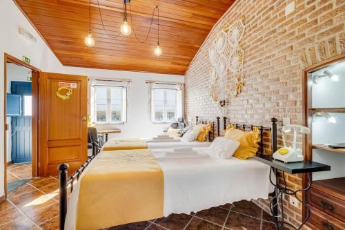 a bedroom with a large bed and a brick wall at Casinha Da Igreja in Igrejinha