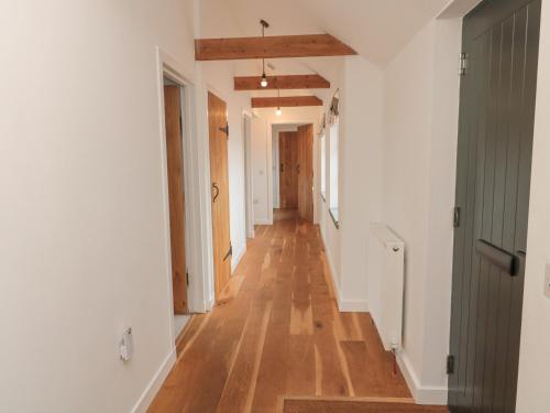 an empty hallway with wooden floors and white walls at Cartshed in Kelso