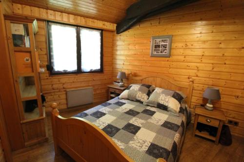 Un dormitorio con una cama en una cabaña de troncos en Maison de style chalet individuelle Le Rouge Feigne à La Bresse, en La Bresse