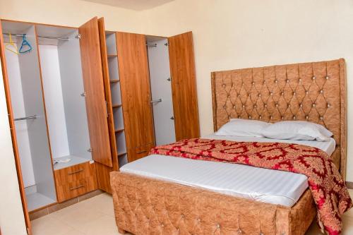 a bedroom with a large bed and a closet at DESIRED 2 BEDROOM Apartment in Thika